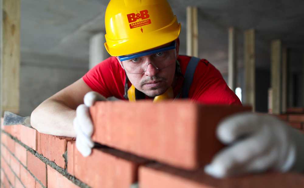 bricklayer aligning brick